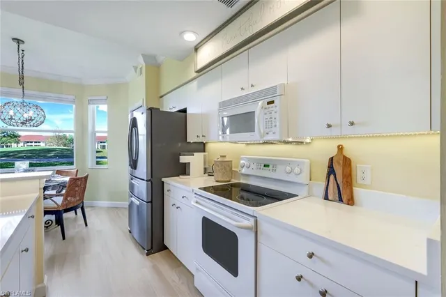 a kitchen with sink a refrigerator and cabinets