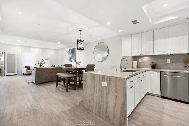 a large kitchen with kitchen island a island a sink a stove a dining table and chairs