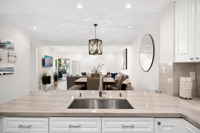 a view with a faucet a sink and a dining table with wooden floor