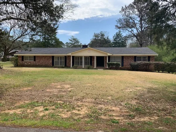 a view of a house with a big yard and large trees