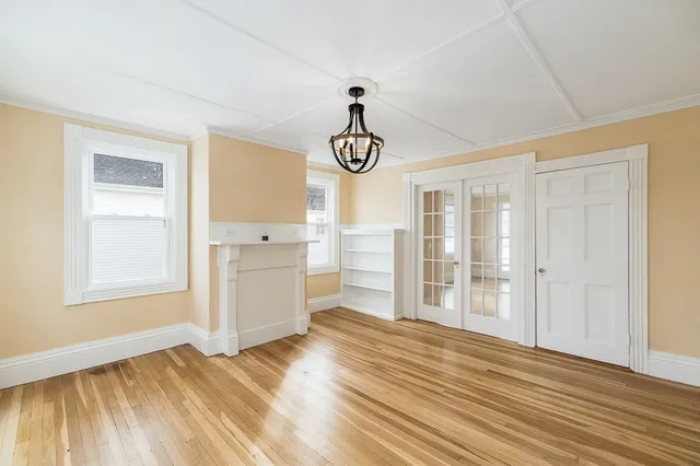 a view of empty room with wooden floor and window