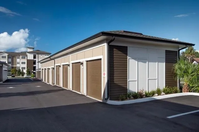a front view of a multi story residential apartment building with yard and retail shops