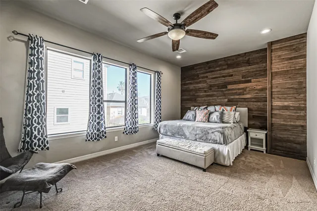 a spacious bedroom with a bed a couch and a large window