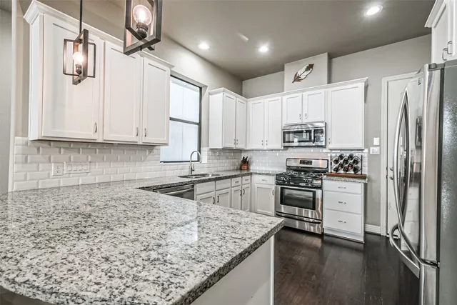a kitchen with white cabinets and stainless steel appliances