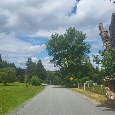 a view of a field of grass and trees