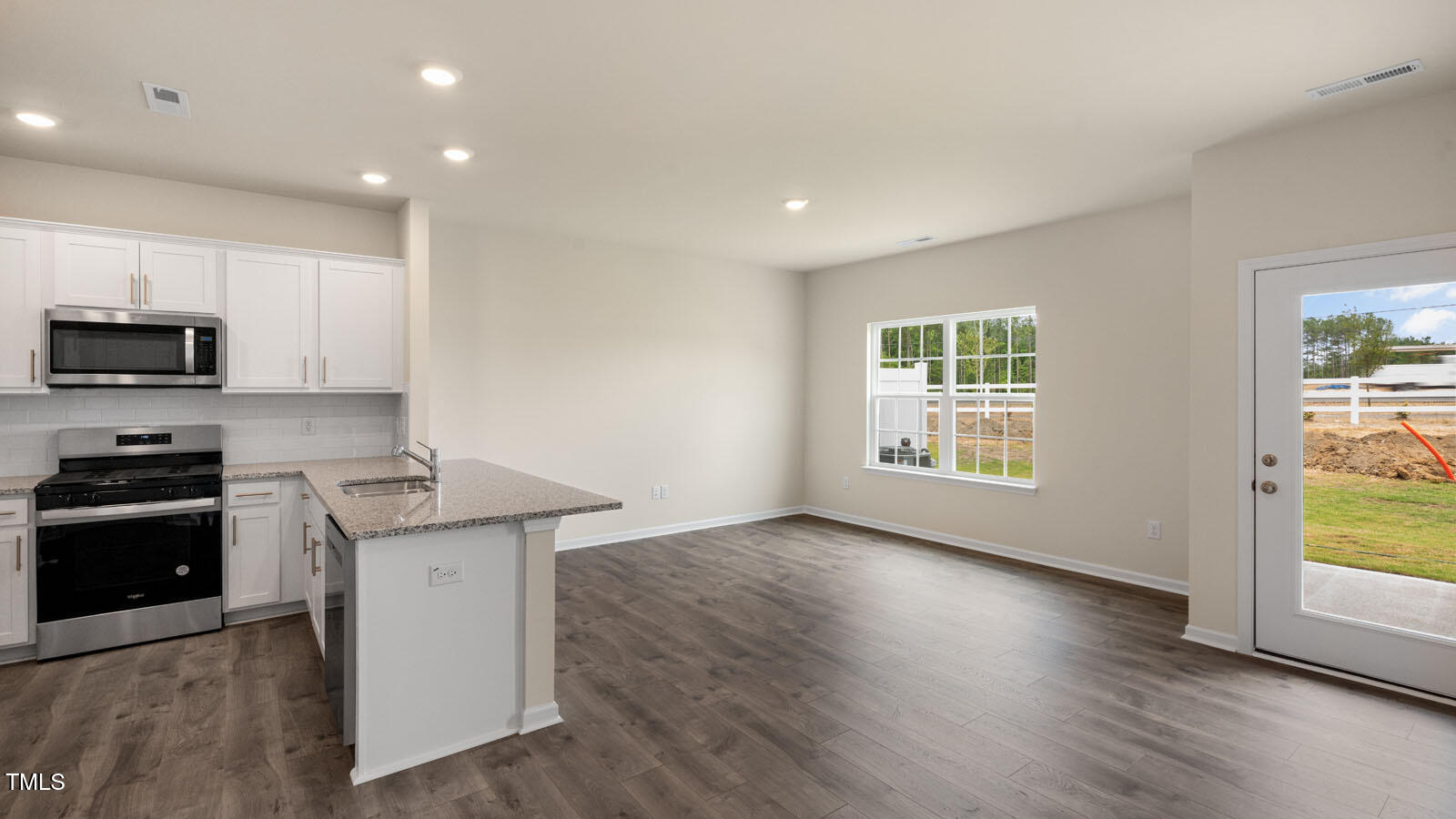 300 Perseus Street Angier, NC 27501 - Photo 11 of 26 a kitchen with granite countertop a stove a sink a refrigerator and a microwave