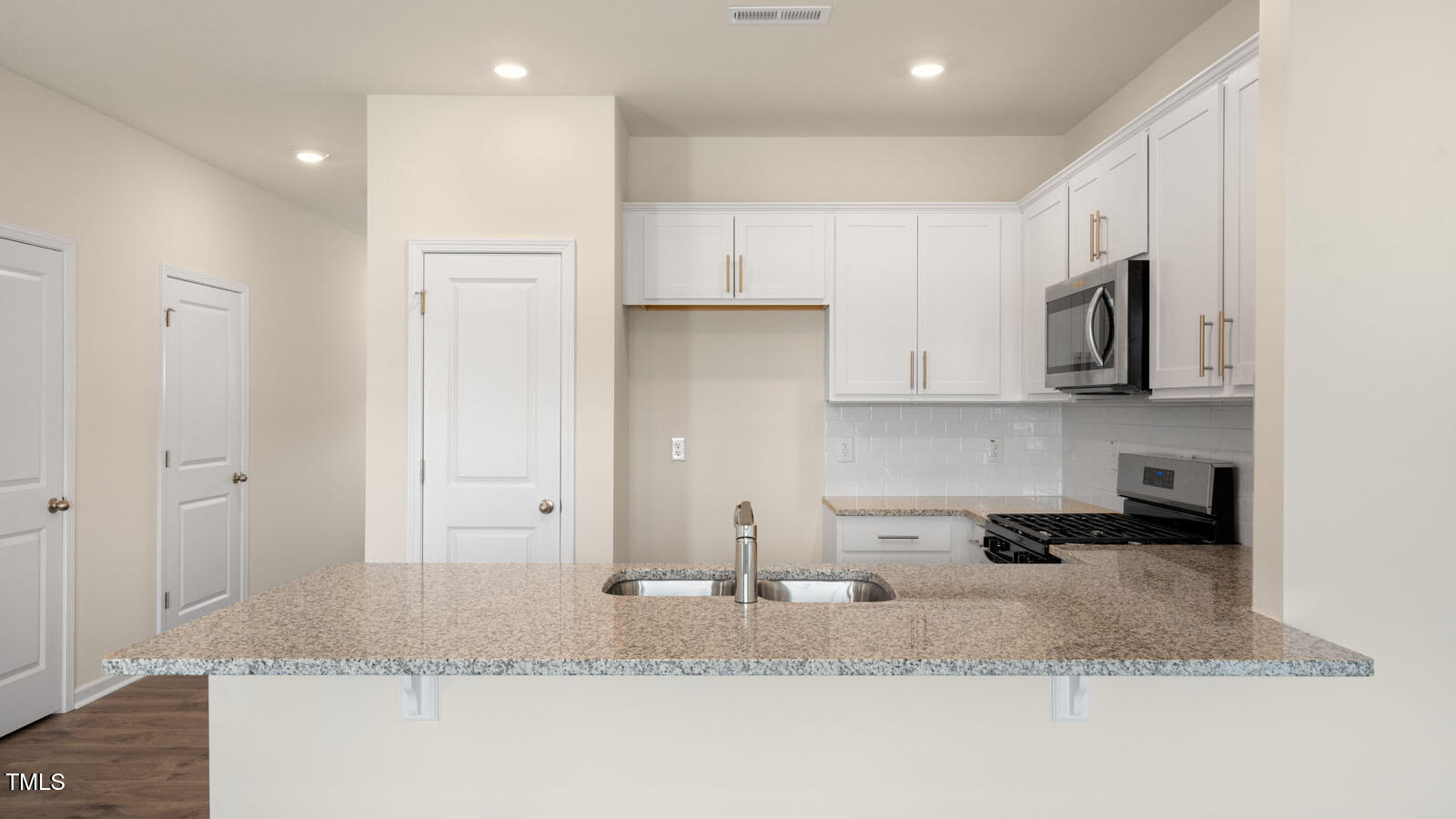 300 Perseus Street Angier, NC 27501 - Photo 10 of 26 a kitchen with stainless steel appliances granite countertop a sink a stove and a refrigerator