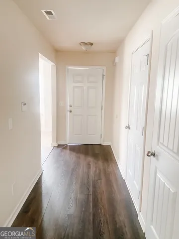a view of a hallway with wooden floor