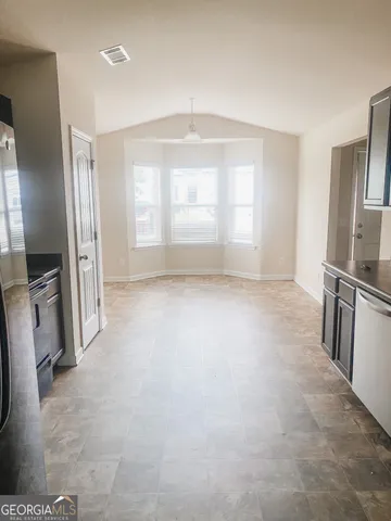 a view of a kitchen with a sink and a refrigerator