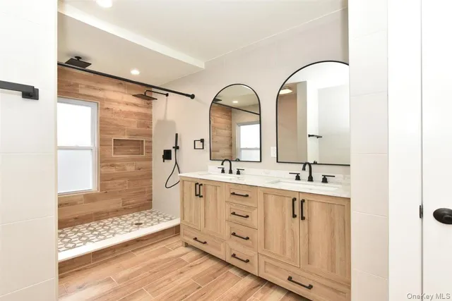 a spacious bathroom with a double vanity sink a mirror and a shower