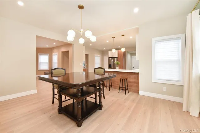 a view of a a dining room with furniture window and wooden floor