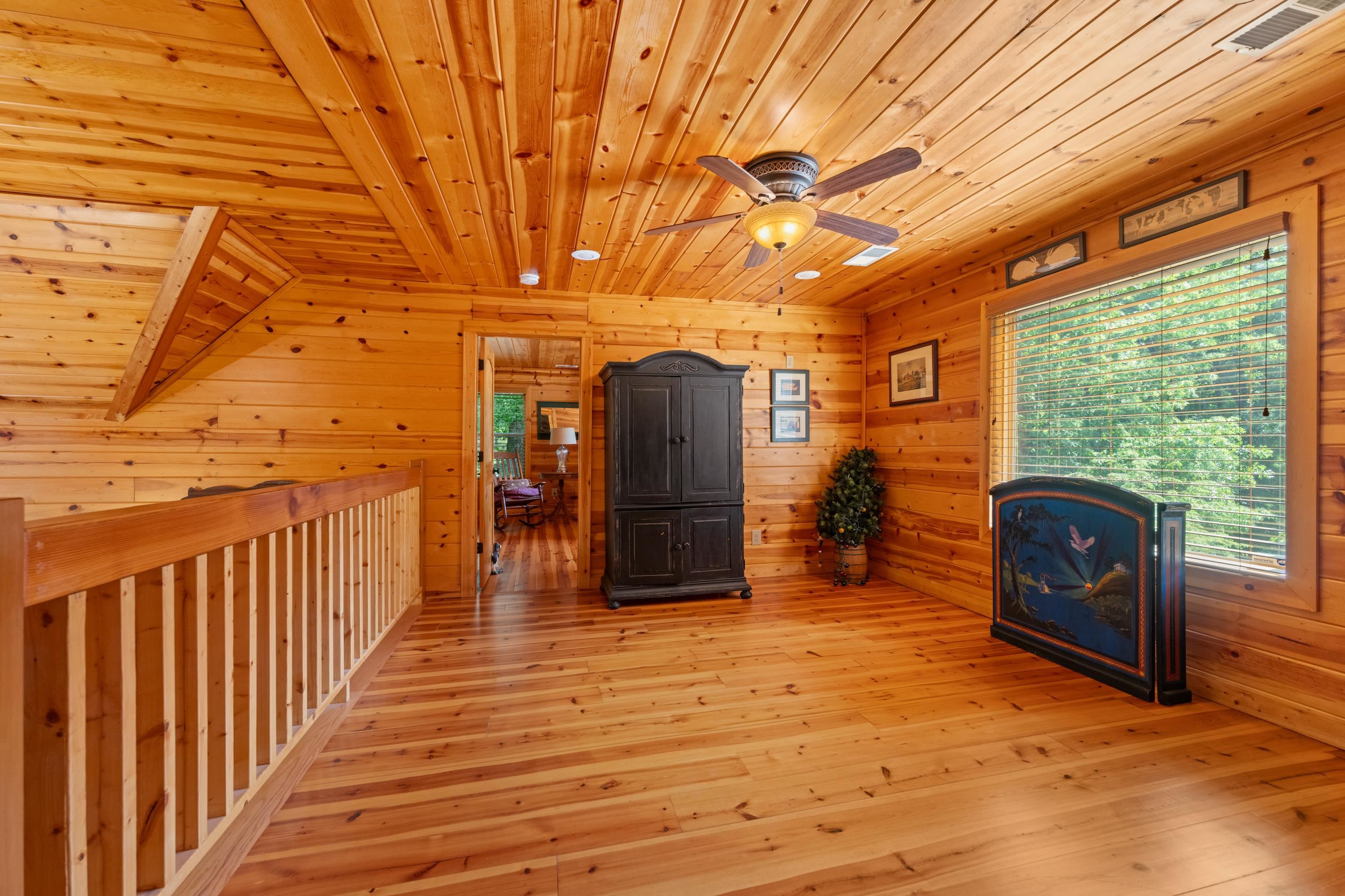 950 Cherry Road Eads, TN 38028 - Photo 17 of 30 Warm wood-paneled room featuring a ceiling fan with integrated lighting, wood-finish flooring, and a large window with horizontal blinds