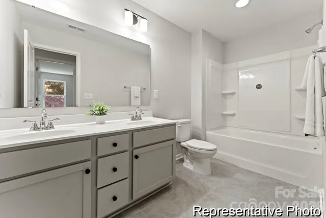 a bathroom with a toilet a sink a tub and a mirror