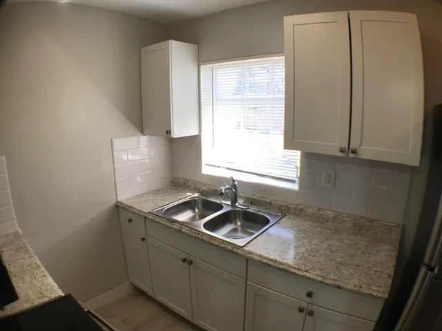 a kitchen with granite countertop a stove and a microwave
