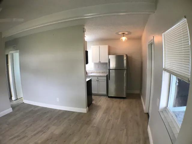 an empty room with wooden floor and a window