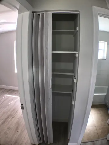 a view of empty room with wooden floor