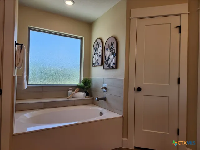 a bathroom with a bathtub and a window