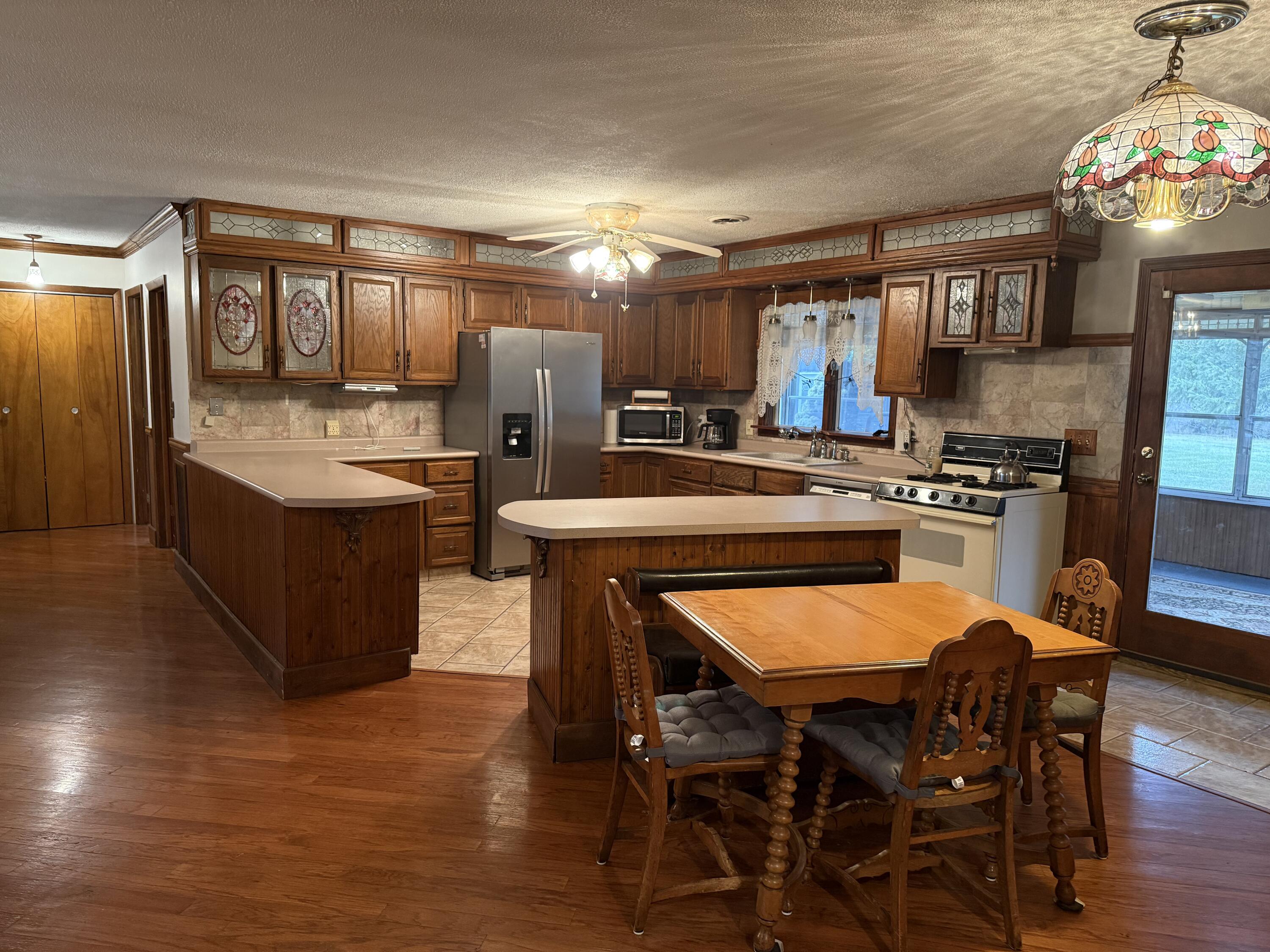 368 South 600th Street West Hebron, IN 46341 - Photo 16 of 87 a kitchen with stainless steel appliances granite countertop a table chairs sink and stove