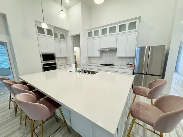 a kitchen with stainless steel appliances a dining table and chairs