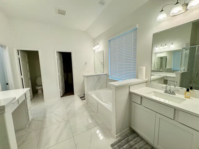 a bathroom with double vanity and a mirror