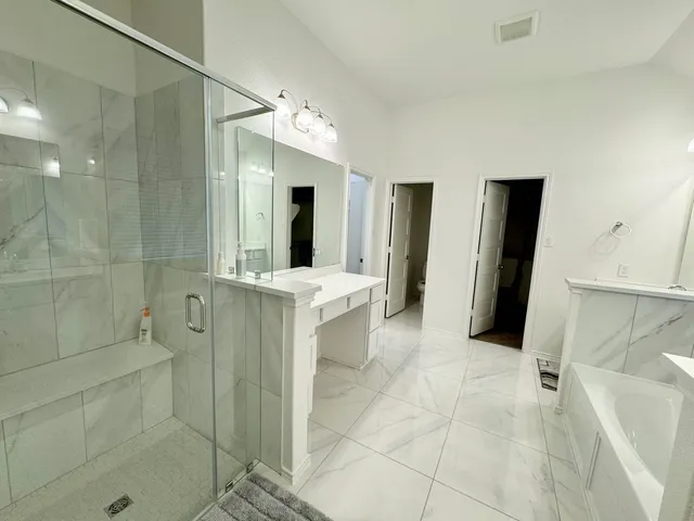 a bathroom with a double vanity sink mirror and shower
