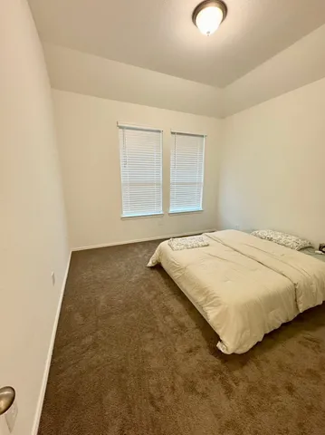 a bed sitting in a bedroom next to a window