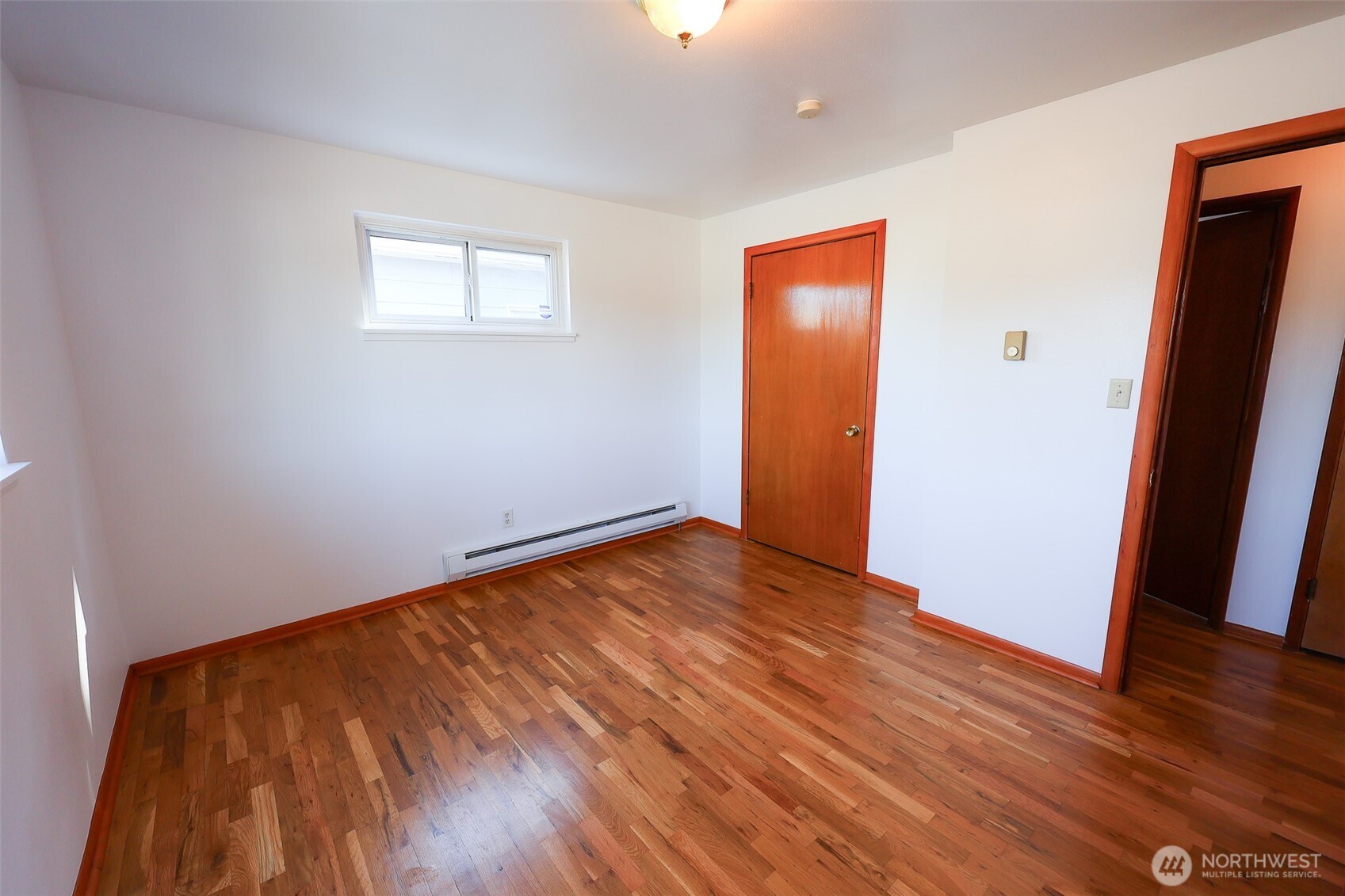 908 Willow Street Sumner, WA 98390 - Photo 18 of 32 an empty room with wooden floor and windows