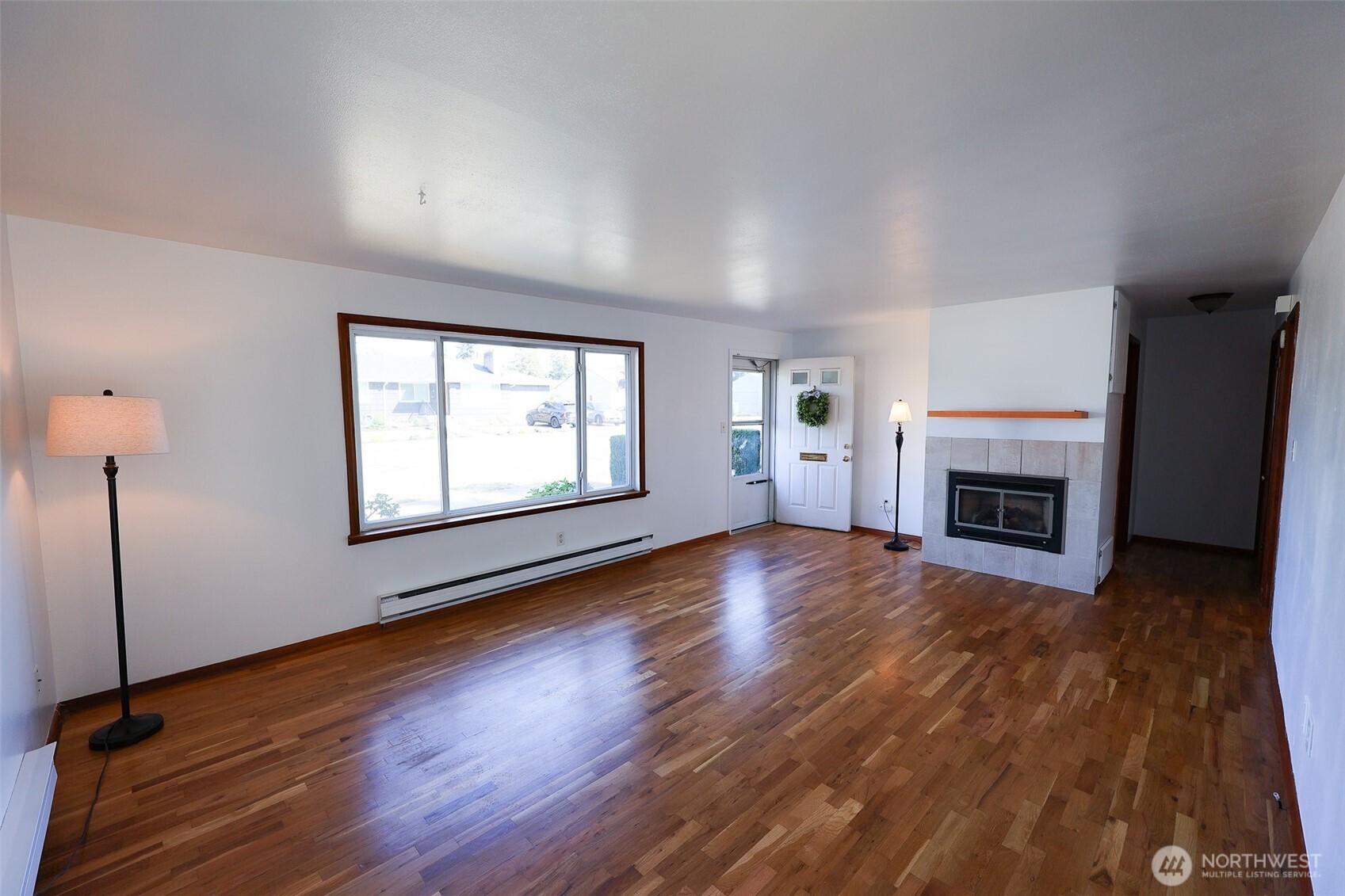 908 Willow Street Sumner, WA 98390 - Photo 3 of 32 an empty room with wooden floor fireplace and windows