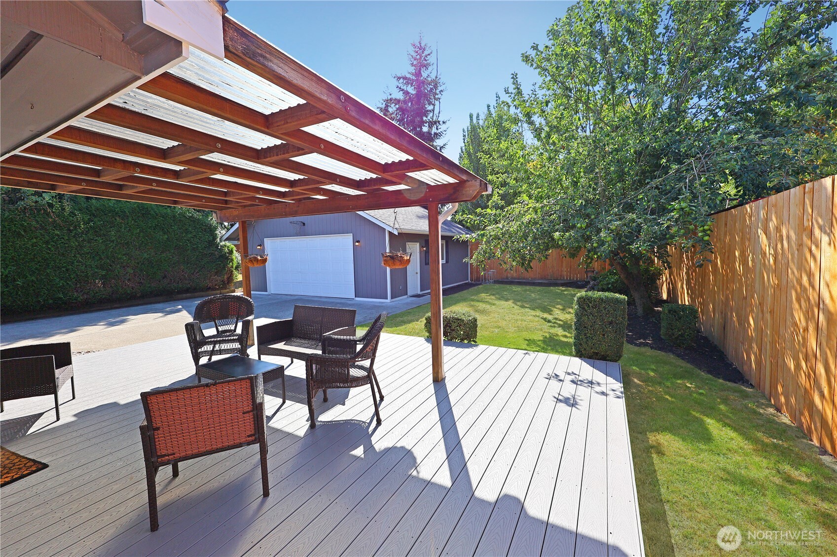 908 Willow Street Sumner, WA 98390 - Photo 10 of 32 a view of a patio with table and chairs under an umbrella with wooden floor and fence