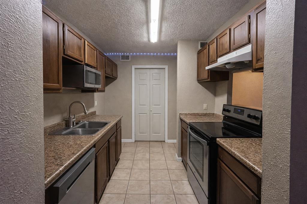 18333 Roehampton Drive, Unit 1117 Dallas, TX 75252 - Photo 4 of 14 a kitchen with granite countertop a sink and a stove