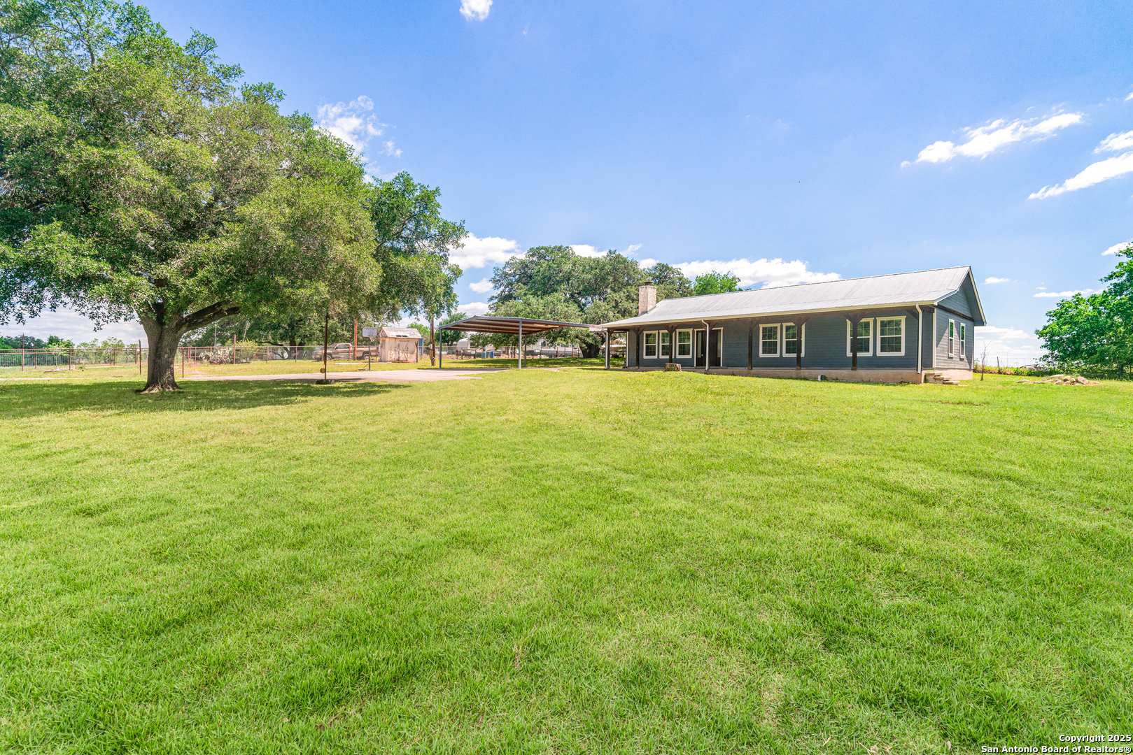 18950 Southton Road Elmendorf, TX 78112 - Photo 9 of 16 a view of a large building with big yard and large trees