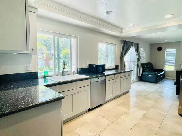 a large kitchen with kitchen island granite countertop a sink a counter top space and cabinets