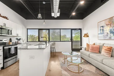 a living room with furniture a flat screen tv and a large window