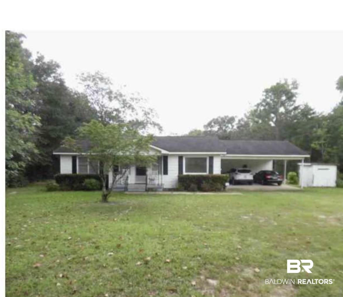 Single story home featuring a carport and a front lawn