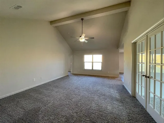 an empty room with windows and ceiling fan