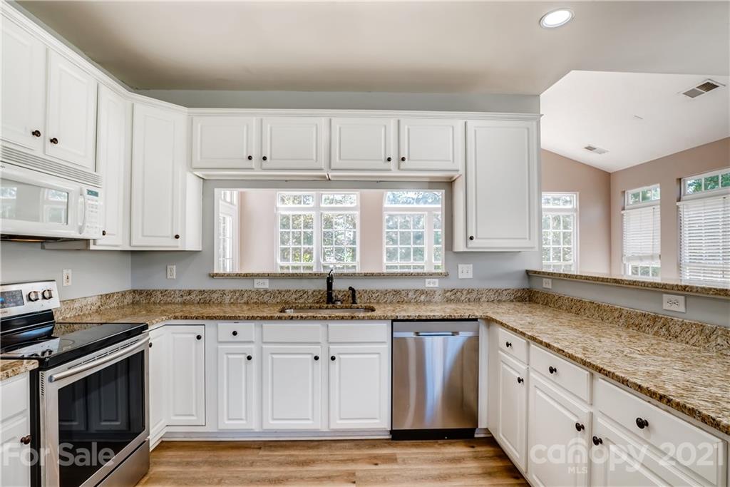 4912 Missi Lane Fort Mill, SC 29708 - Photo 11 of 33 a kitchen with granite countertop a sink white cabinets and stainless steel appliances
