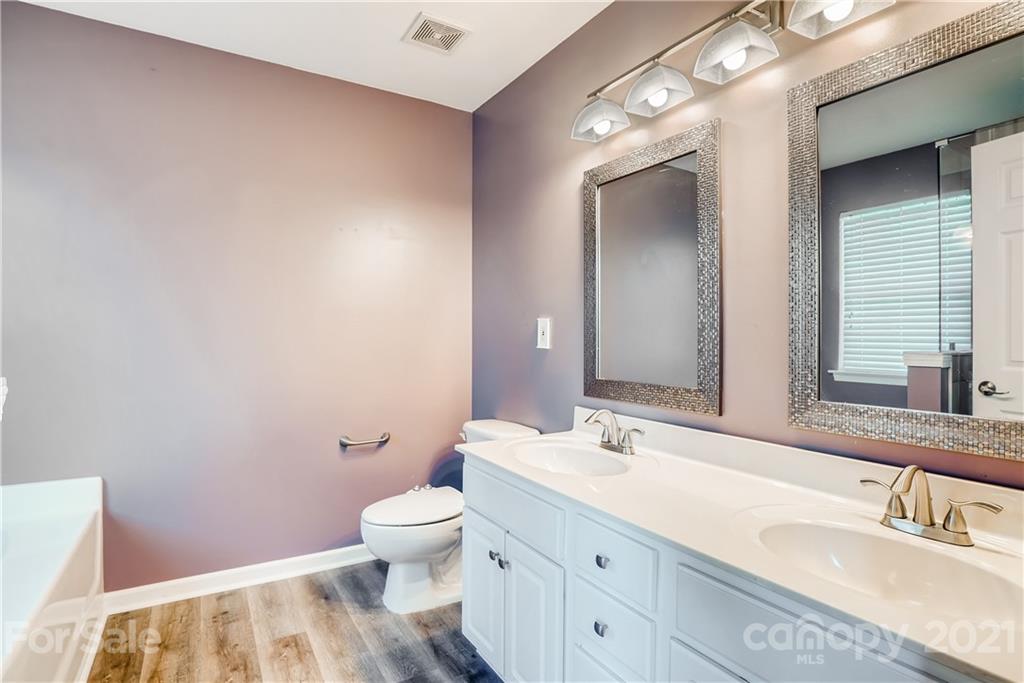 4912 Missi Lane Fort Mill, SC 29708 - Photo 22 of 33 a bathroom with a granite countertop sink a toilet and a mirror