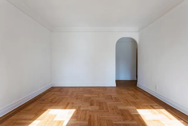 a view of a room with wooden floor and white walls