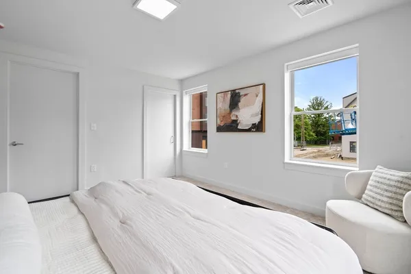 a bedroom with a bed and a painting on the wall