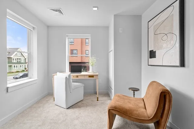 a living room with furniture a window and a painting