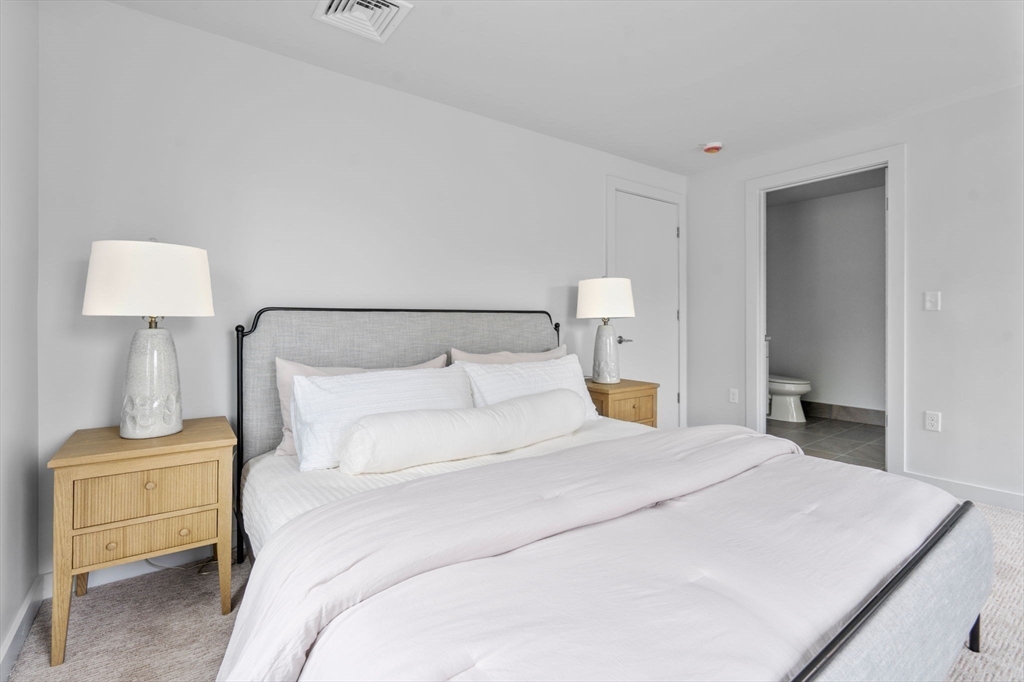 3 B Wilson Street, Unit 3B Natick, MA 01760 - Photo 20 of 33 a bedroom with a bed and a lamp