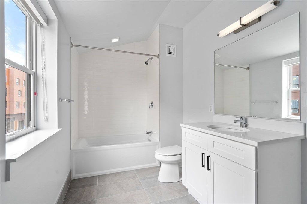 3 B Wilson Street, Unit 3B Natick, MA 01760 - Photo 24 of 33 a bathroom with a tub sink toilet and a mirror