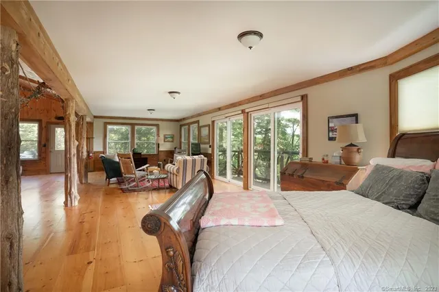 a large bedroom with bed and large windows