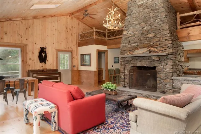 a living room with furniture a fireplace and a chandelier