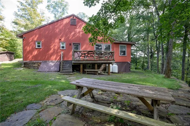 a view of a house with backyard and a tree