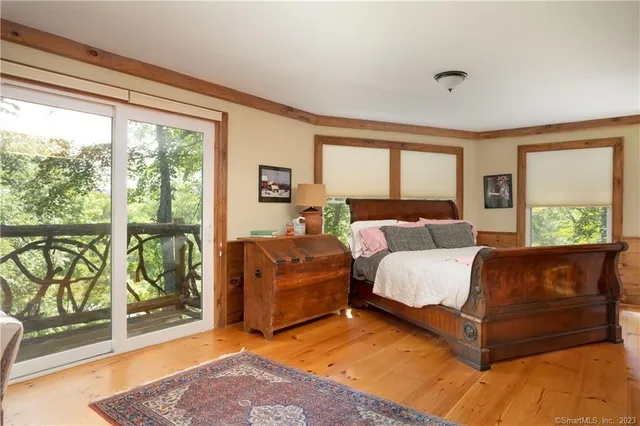 a spacious bedroom with a bed and glass window