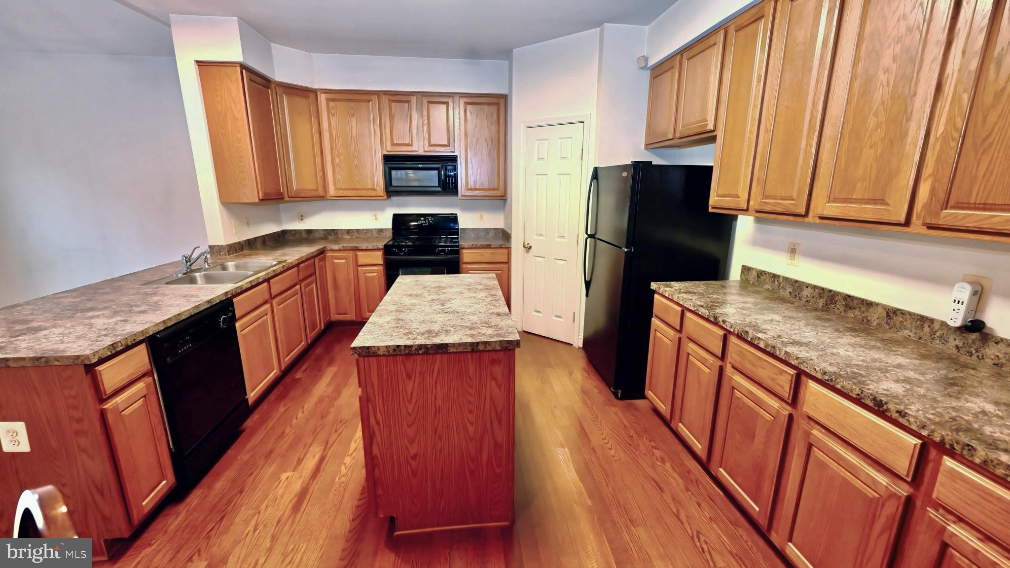 11258 Wildmeadows Street Waldorf, MD 20601 - Photo 3 of 33 a kitchen with granite countertop wooden cabinets a sink a stove a refrigerator and dishwasher with wooden floor