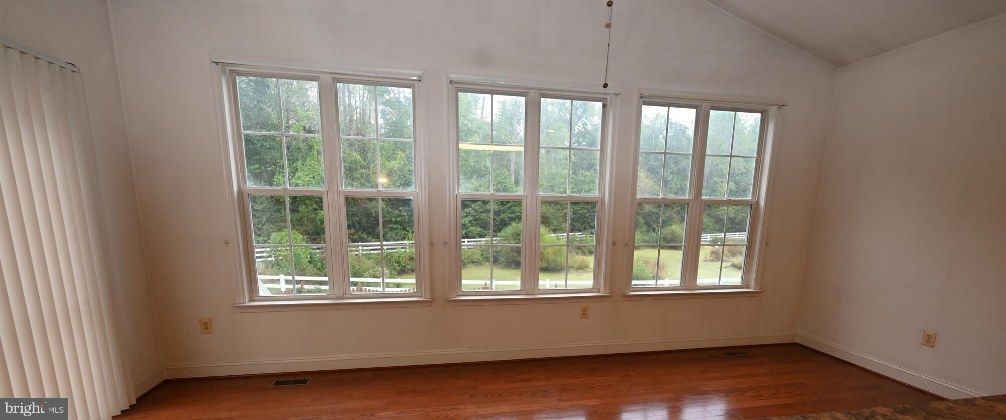 11258 Wildmeadows Street Waldorf, MD 20601 - Photo 6 of 33 a view of an empty room with wooden floor and a window