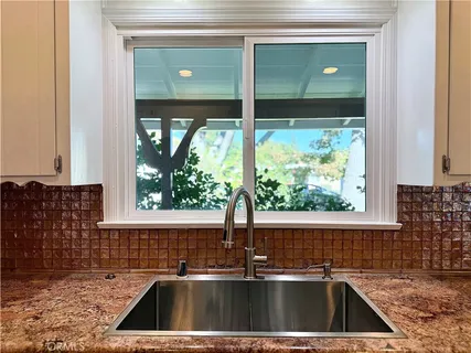 a kitchen with granite countertop white cabinets and stainless steel appliances