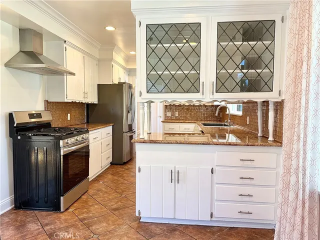 a kitchen with granite countertop white cabinets and white appliances